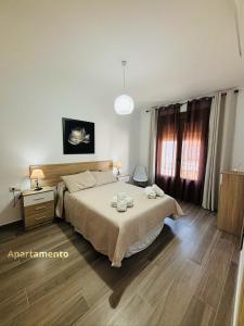 a bedroom with a large bed and a wooden floor at Descanso de Dulcinea in Almagro
