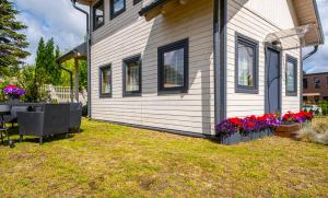 una casa con una mesa y flores en el patio en Domki Bukowy Las, en Rewa