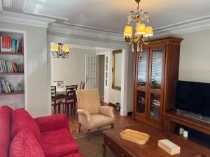 a living room with a red couch and a tv at Garden Beach Apartament in Boiro