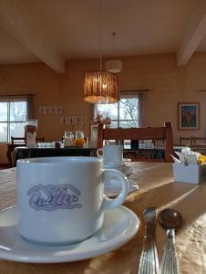 a coffee cup on a plate on a table at Posada Quellen in Villa General Belgrano