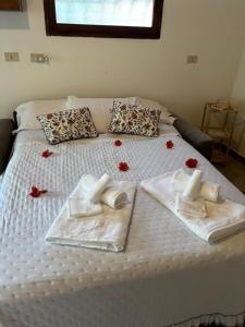 een bed met witte lakens en rode rozen erop bij Cozy house in the Chianti region in Castelnuovo Berardenga