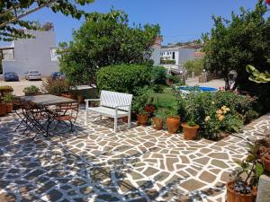 a patio with a table and chairs and plants at Villa Joanna in Batsi