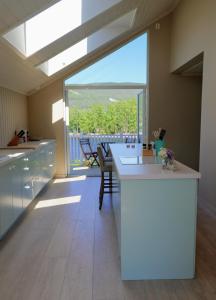 a kitchen with a white counter and a large window at Summer place by the river in Mjøndalen