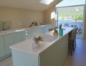 a large kitchen with a large counter with flowers on it at Summer place by the river in Mjøndalen +25 photos