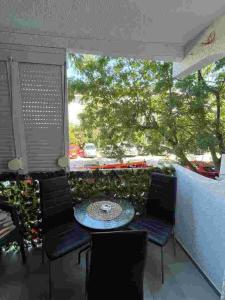 a balcony with a table and chairs and a tree at Sivas Bar in Bar
