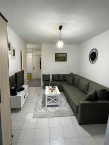 a living room with a green couch and a tv at Sivas Bar in Bar