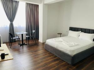 a bedroom with a bed and a table and chairs at Te gjoli in Pogradec