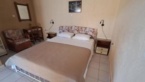 ein Schlafzimmer mit einem Bett und einem Stuhl in der Unterkunft Mpezas Studios in Igoumenitsa