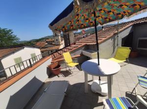 a patio with chairs and an umbrella on a roof at Casa CIOLI in Vinci