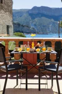 stół z jedzeniem z dwoma krzesłami w obiekcie Le Jardin d'Emile w Cassis