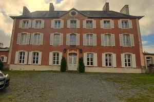 a large brick house with white windows and a door at Chambres d'hôtes de charme dans maison de maitre XIXème in Périers