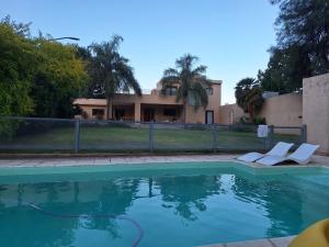 a swimming pool with two lounge chairs in front of a house at Casa Quebrada y Luna in La Rioja