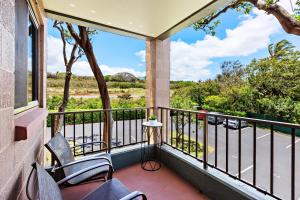 een balkon met stoelen en uitzicht op een straat bij Kahana Manor 316 condo in Kahana