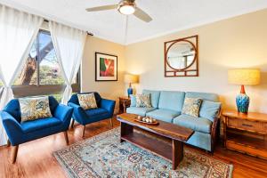 een woonkamer met een blauwe bank en twee stoelen bij Kahana Manor 316 condo in Kahana