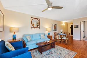 een woonkamer met een blauwe bank en een tafel bij Kahana Manor 316 condo in Kahana