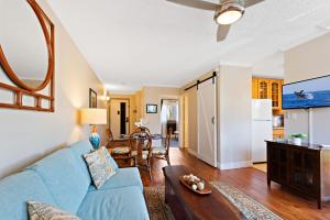 een woonkamer met een blauwe bank en een tafel bij Kahana Manor 316 condo in Kahana