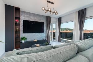 sala de estar con sofá grande y ventanas grandes en Penthouse Luka, en Trogir
