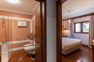 a bathroom with a bed a toilet and a shower at IKIGAI Gerês - A Lake Edition in Geres +37 photos