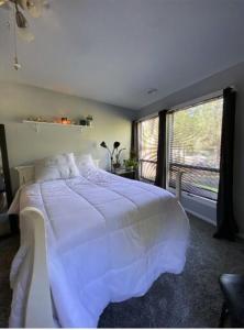a bedroom with a large white bed with a window at Large Recreational Retreat in Hudson
