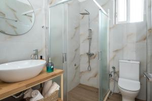 a bathroom with a sink and a glass shower at Lilian Home Just Steps from the Beach in Minia