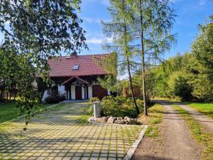 a house with a red roof and a driveway at Dom Na Pstrążnicy in Kudowa-Zdrój