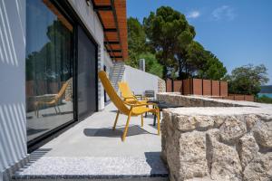 a yellow chair sitting on a patio next to a building at Ionian Grand Villas - Villa Helena in Lygia