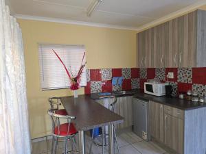 a kitchen with a table and chairs and a microwave at JayLa SELFCATERING ACCOMMODATION in Windhoek