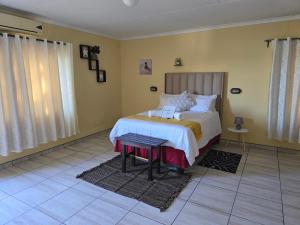 a bedroom with a bed and a table in it at JayLa SELFCATERING ACCOMMODATION in Windhoek