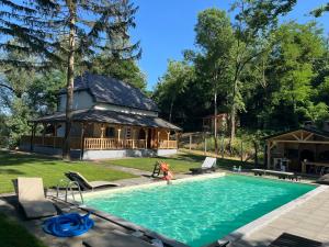 a person in a pool with a house in the background at Elowen in Novo Selo