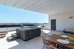 Un gran patio con jacuzzi en la azotea. en Penthouse Luka, en Trogir