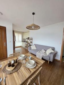 a living room with a table and a couch at Costa Foz Apartment Playa de Llas, terraza, piscina y pista de pádel in Foz