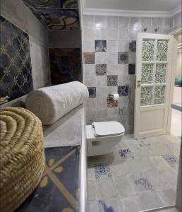 a bathroom with a toilet and a door with tiles at Luxurious apartment close to all amenities in Agadir
