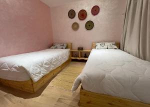a bedroom with two beds and a wall with clocks at Luxurious apartment close to all amenities in Agadir