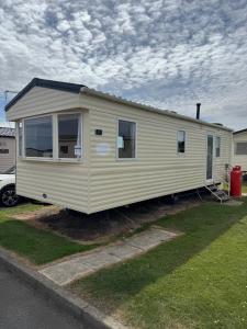 a small yellow house is parked in a yard at ABI Vista Caravan, Whitley Bay in Whitley Bay