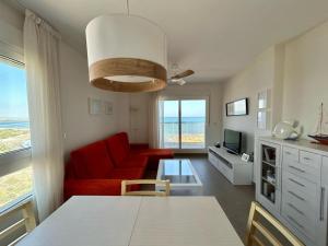 a living room with a red couch and a table at BEACH SUN SPIRIT, spa & gym in La Manga del Mar Menor