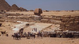 un gruppo di persone sui cammelli alle piramidi di Pyracave pyramids view a Il Cairo