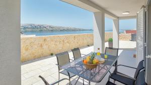 ein Tisch und Stühle auf einem Balkon mit Blick auf das Meer in der Unterkunft Vila Bernarda by Resort Čulina in Metajna