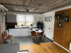 a kitchen and dining room with a table and chairs at T&E Apartament in Żywiec