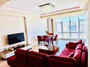 a living room with a red couch and a table at Secrets Center Family Apartment in Mekhrably +10 photos