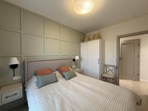 a bedroom with a large white bed with pillows at Cosmo Apartments Baltic Sea in Gdańsk