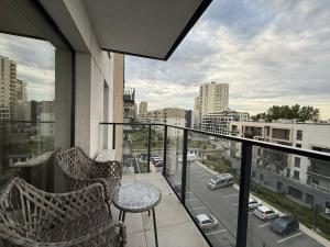a balcony with two chairs and a view of a city at Cosmo Apartments Baltic Sea in Gdańsk