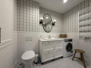 a bathroom with a toilet and a sink and a washing machine at Cosmo Apartments Baltic Sea in Gdańsk