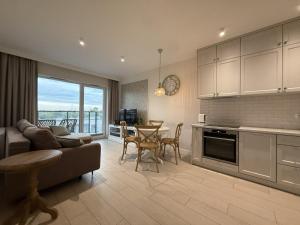 a kitchen and living room with a couch and a table at Cosmo Apartments Baltic Sea in Gdańsk