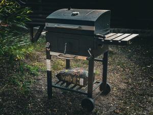 a grill sitting on a stand in the grass at Sfera Place in Ineu