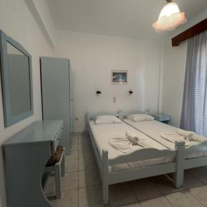 a bedroom with a bed and a desk and a mirror at Villa Eleni - Thassos Town in Limenas