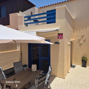 コスタ・カルマにあるLa Cabaña - Fuerteventuraの建物の前にパティオ(テーブル、椅子付)