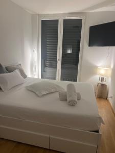 日内瓦Coqueto的卧室里有一张白色的床，床上有两条毛巾