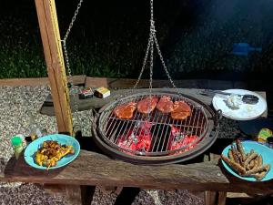 a grill with meat and other food on a table at Gîtes les Perouilles - La grange d'Angèle in Puymiclan