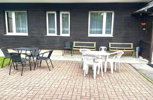 a patio with a table and chairs and benches at Gościniec Bolero in Szklarska Poręba