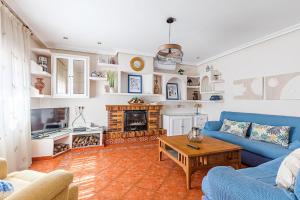 a living room with a blue couch and a table at Villa Cristina con piscina privada y BBQ in Carranque